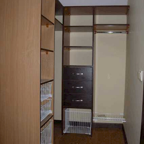 Г-образная гардеробная комната с сетчатыми корзинами и ящиками